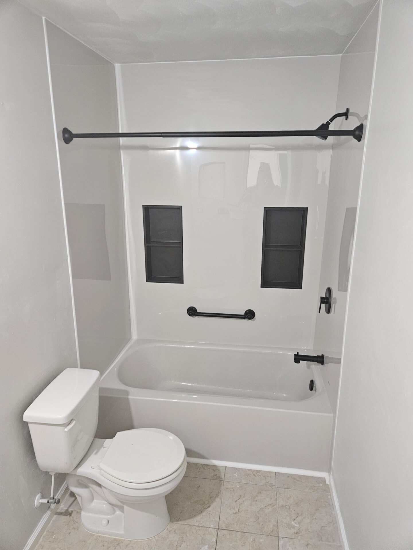 http://Shower%20to%20bathtub%20conversion%20with%20flat%20white%20walls,%20ADA%20compliant%20grab%20bars%20and%20two%20niche%20boxes